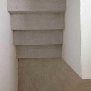 escalier en béton ciré avec palier en béton ciré créé une uniformité de coueleur à l'ecalier en enduit décoratif